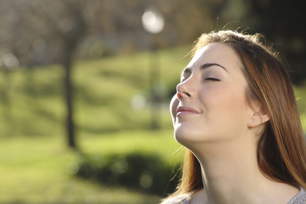 Portrait of a relaxed woman breathing deep in a park - Inner Fulfillment